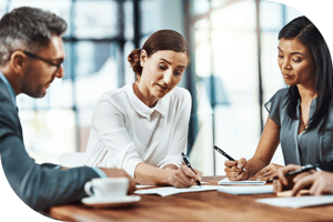 Three professionals taking notes at a meeting