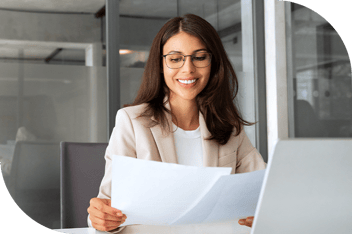 Professional reviewing paperwork at a computer