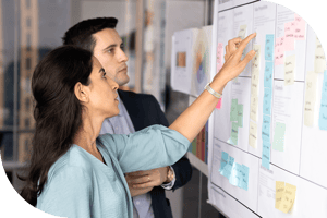 Two professionals plotting a timeline with sticky notes