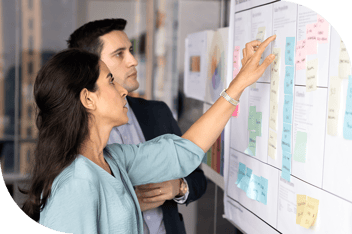 Two professionals plotting a timeline with sticky notes