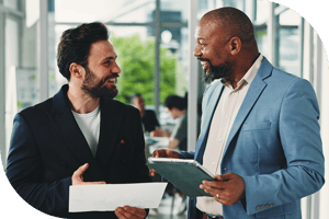 Two professionals smiling over paperwork in the hall