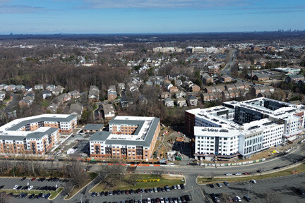 Aerial view of three large apartment complexes in a neighborhood of houses