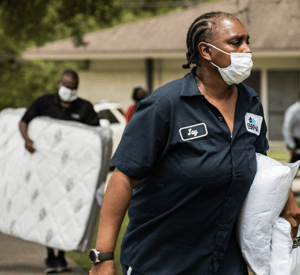 Volunteers carry pillows and mattresses to resident homes