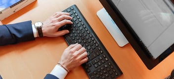 Hands typing on computer keyboard