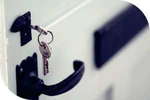 Keys hanging from lock on a white door