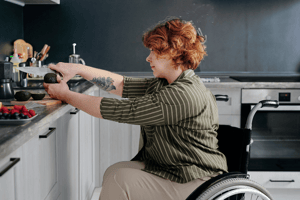 Woman in wheelchair preparing food at counter
